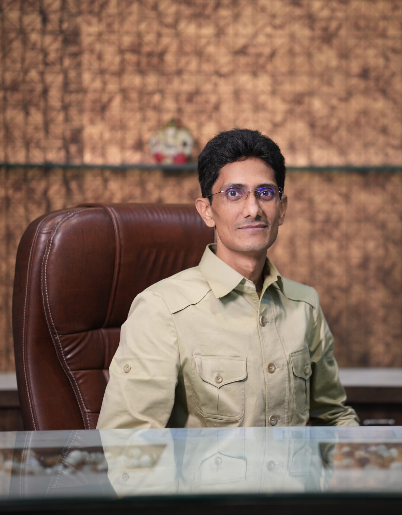 Hariram rinwa in a tan shirt at a desk.